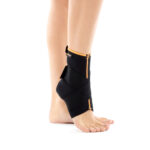 Siyah Çapraz Bantlı Ayak Bilekliği takan bir kişinin bacağı